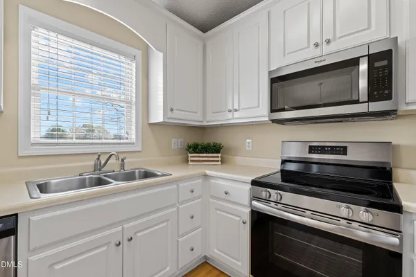 a kitchen with appliances a sink and cabinets