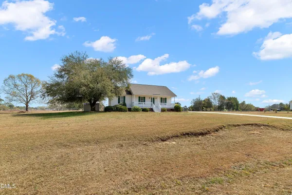 a view of a house with a yard and tree s