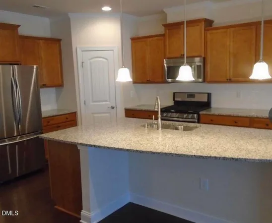 a kitchen with stainless steel appliances granite countertop a sink a stove and a refrigerator