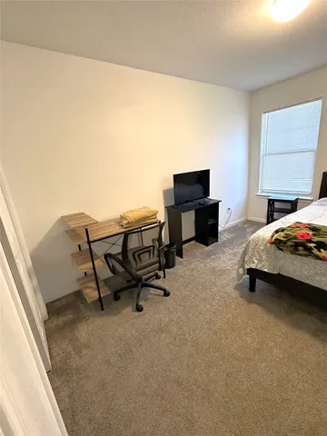 a bedroom with a bed and a desk