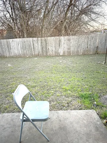a view of a backyard with plants and a chair