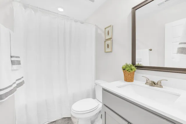 a bathroom with a granite countertop sink and a toilet