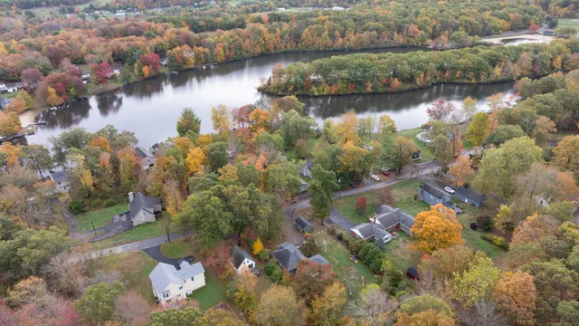 an aerial view of residential houses with outdoor space and lake view
