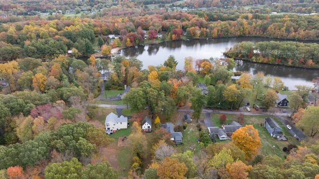 an aerial view of residential houses with outdoor space and lake view