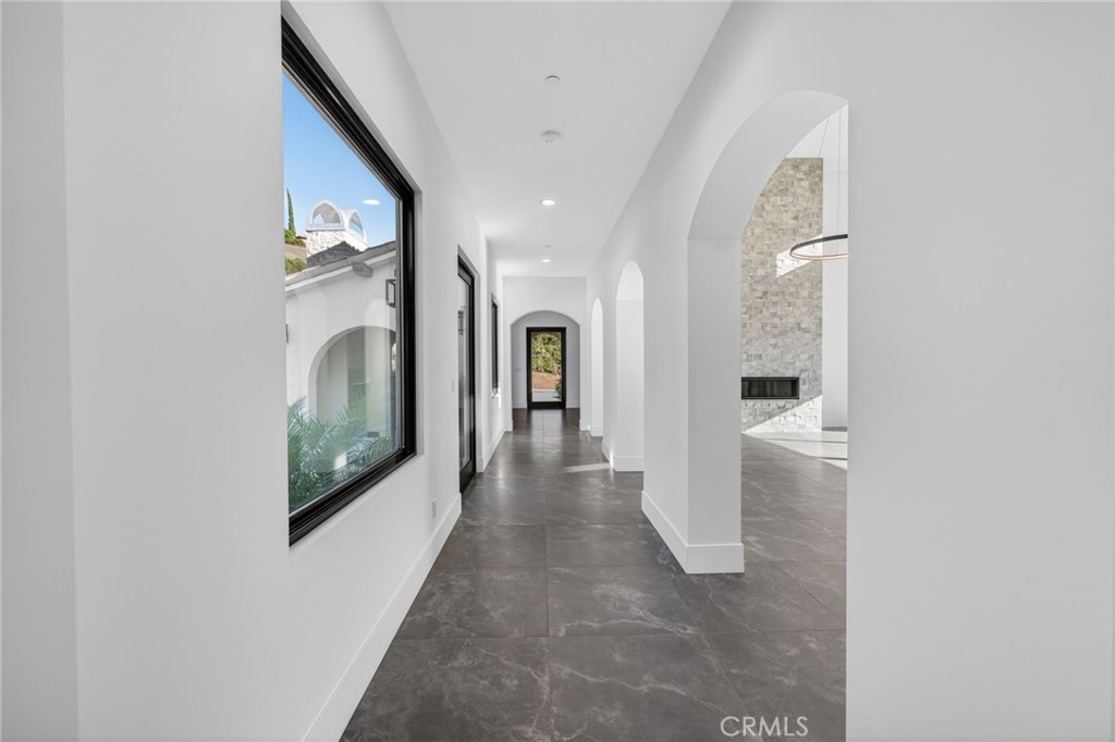 43754 De Luz Road Temecula, CA 92590 - Photo 33 of 74 a view of a hallway with a white walls and a flat screen tv