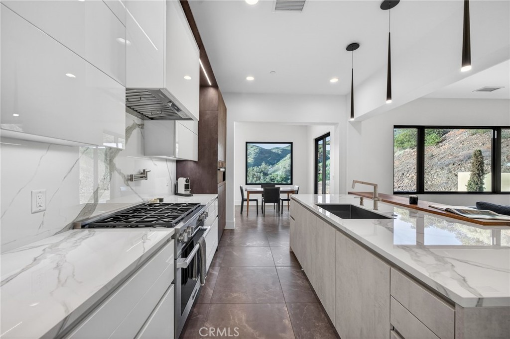 43754 De Luz Road Temecula, CA 92590 - Photo 45 of 74 a kitchen with stainless steel appliances a sink a stove and chairs