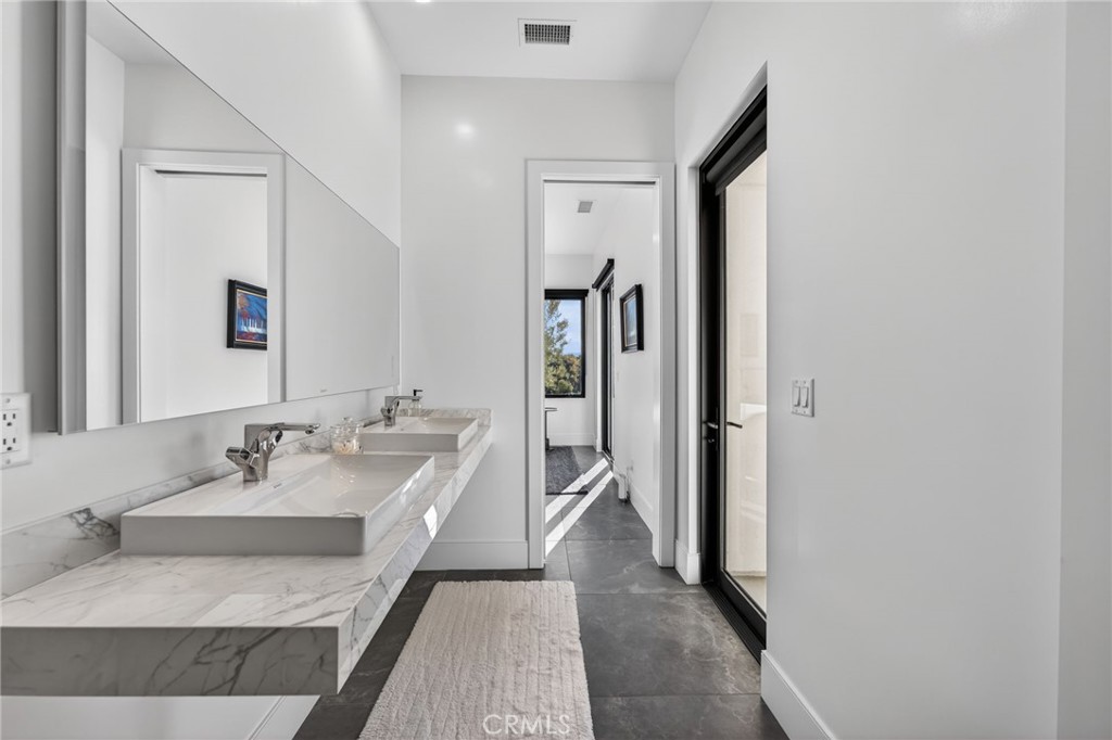43754 De Luz Road Temecula, CA 92590 - Photo 59 of 74 a en suite bathroom with a granite countertop sink and a mirror