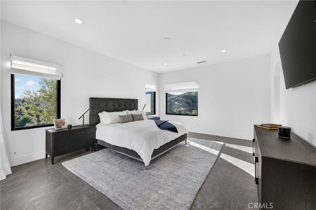 43754 De Luz Road Temecula, CA 92590 - Photo 61 of 74 a spacious bedroom with a bed and a flat tv screen on the dresser