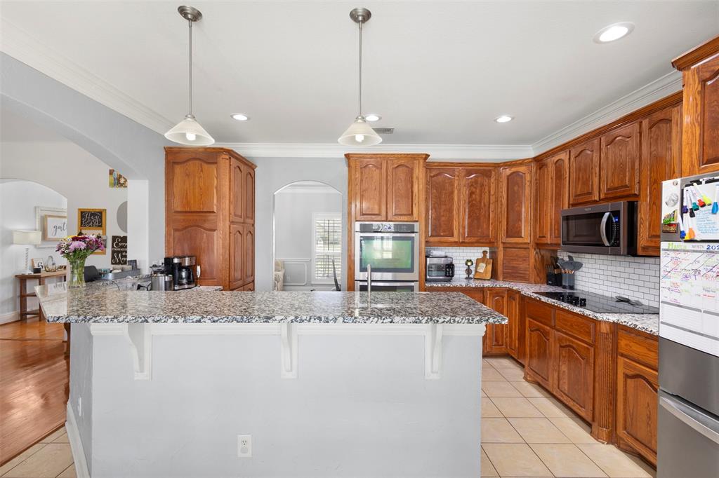 2000 Pin Oak Drive Kaufman, TX 75142 - Photo 11 of 40 a kitchen with stainless steel appliances granite countertop a sink a stove and a refrigerator