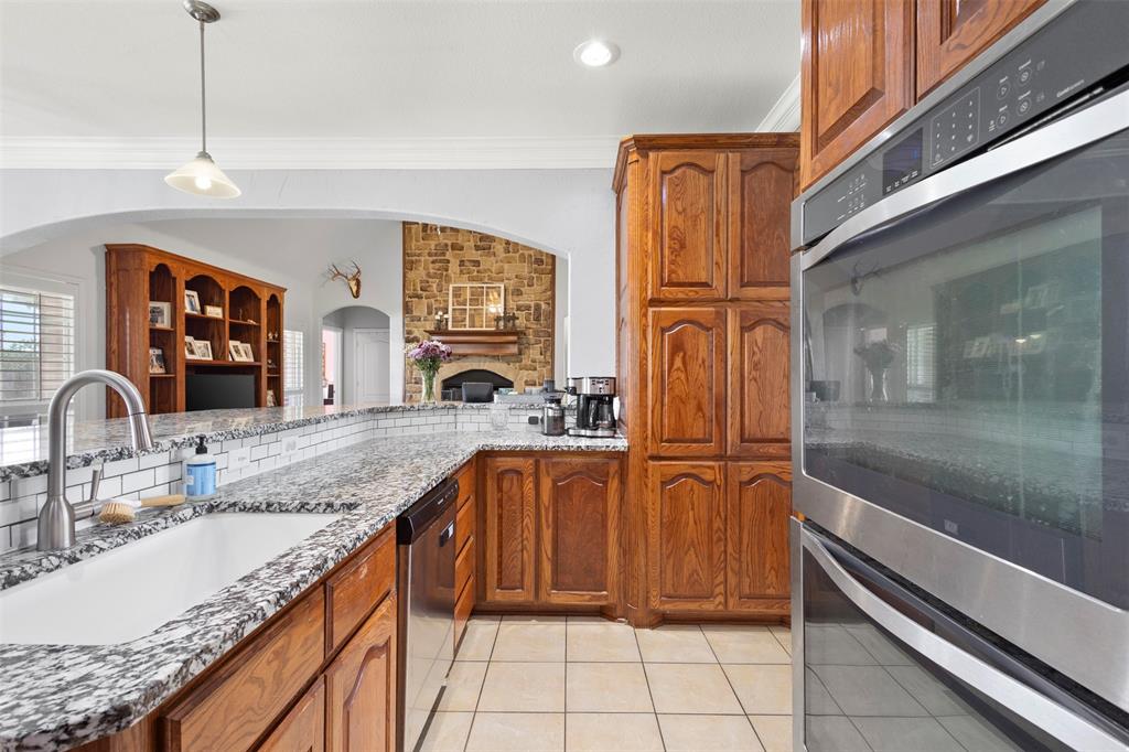 2000 Pin Oak Drive Kaufman, TX 75142 - Photo 13 of 40 a kitchen with stainless steel appliances granite countertop a sink and wooden cabinets