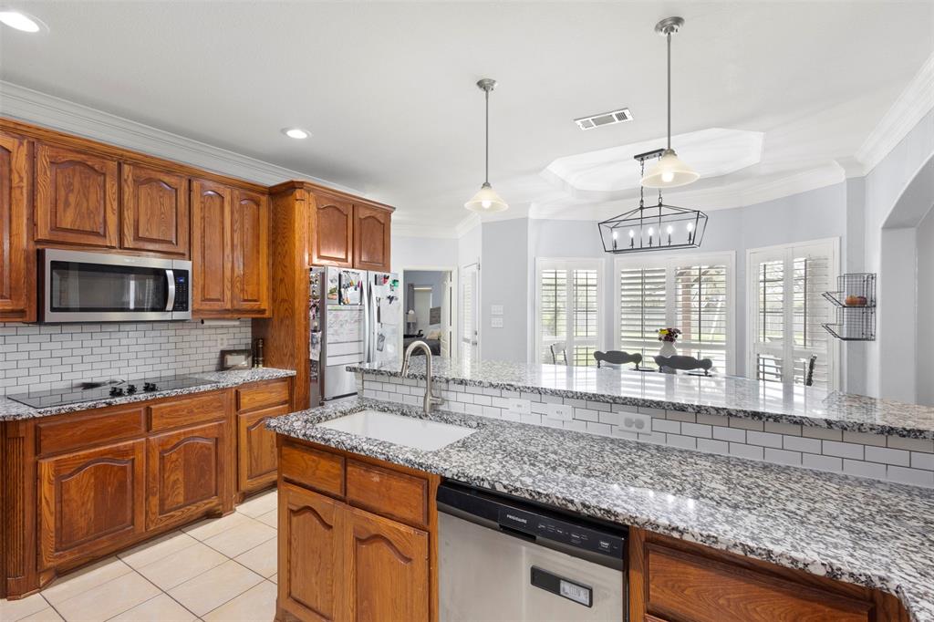 2000 Pin Oak Drive Kaufman, TX 75142 - Photo 15 of 40 a kitchen with stainless steel appliances granite countertop a sink a stove and a wooden cabinets