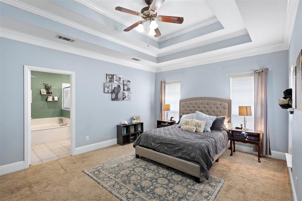 2000 Pin Oak Drive Kaufman, TX 75142 - Photo 25 of 40 a bedroom with a large bed and a chandelier fan