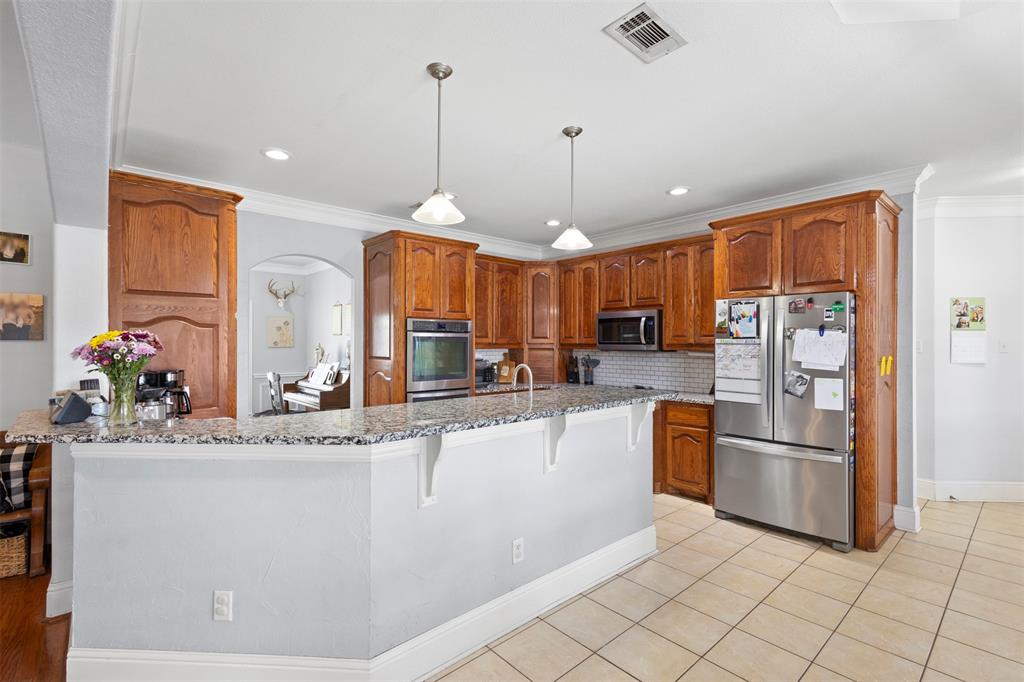 2000 Pin Oak Drive Kaufman, TX 75142 - Photo 10 of 40 a kitchen with stainless steel appliances granite countertop a refrigerator a sink and a stove