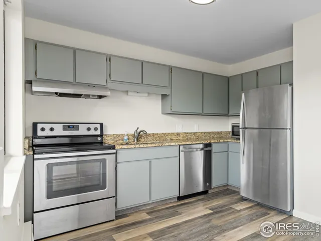 a kitchen with stainless steel appliances granite countertop a stove a sink and a microwave