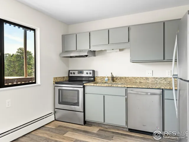 a kitchen with a refrigerator and a stove top oven