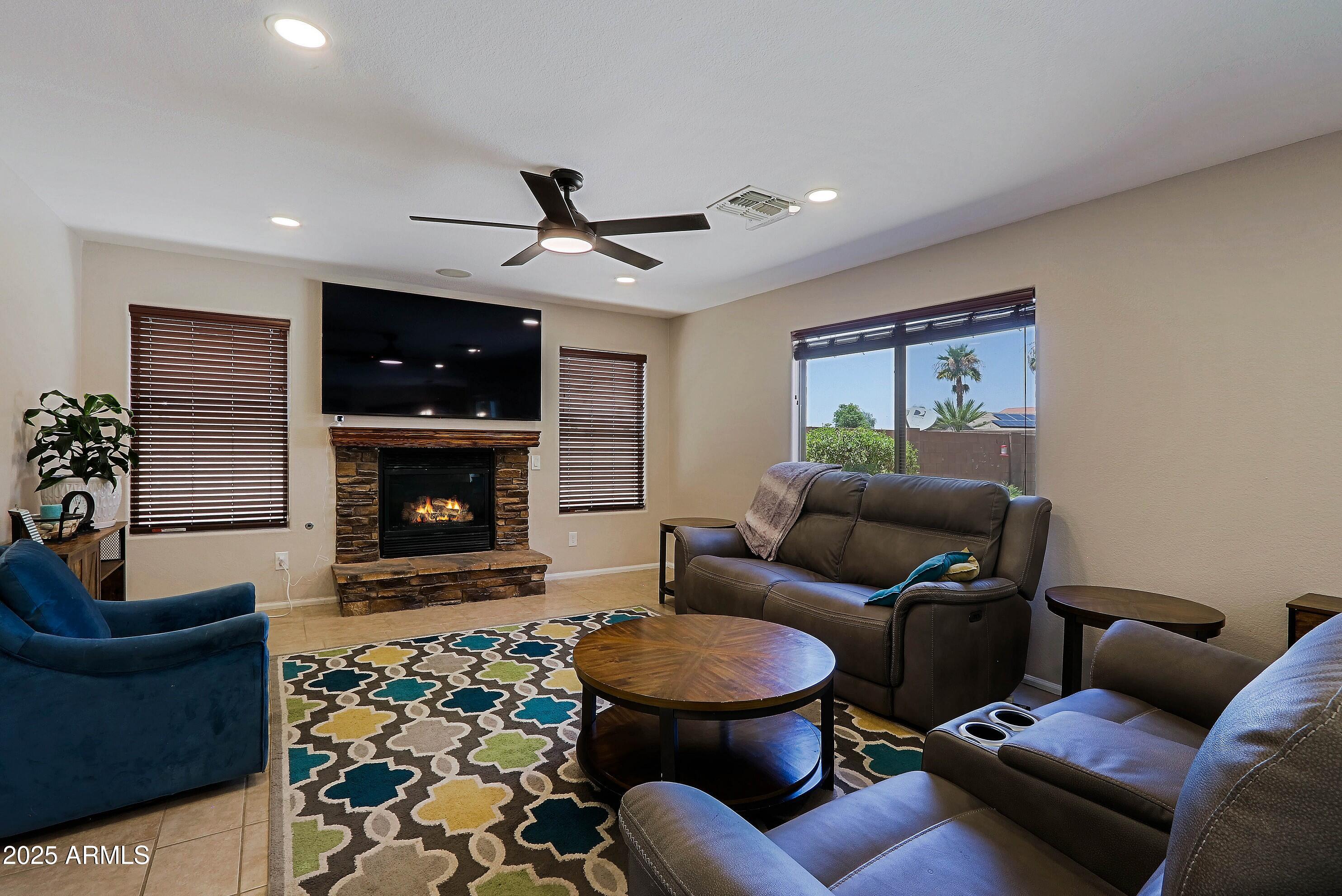 42812 West Venture Road Maricopa, AZ 85138 - Photo 5 of 58 a living room with furniture a flat screen tv and a fireplace