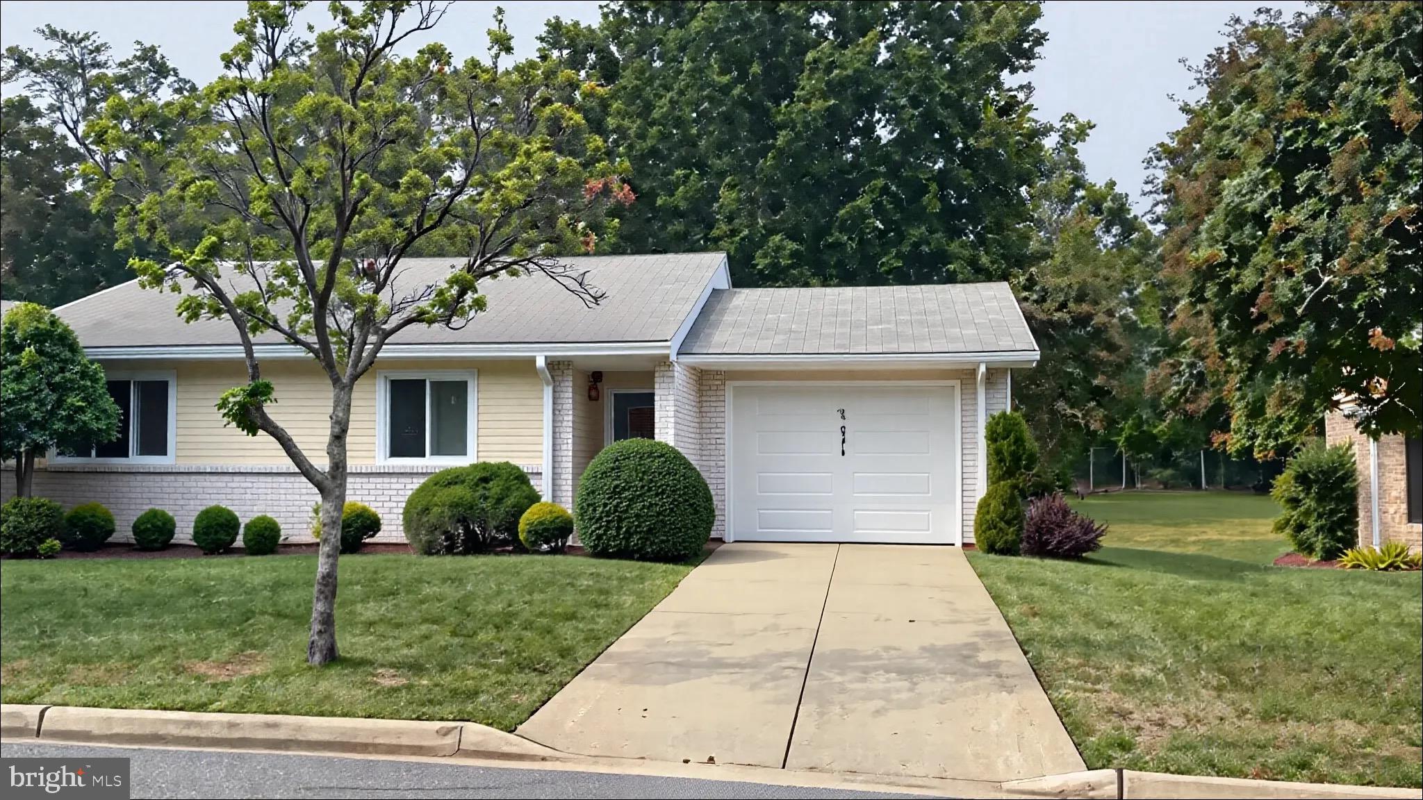 3525 Tarkington Lane, Unit 63B Silver Spring, MD 20906 - Photo 1 of 36 a view of a white house with a yard plants and large tree