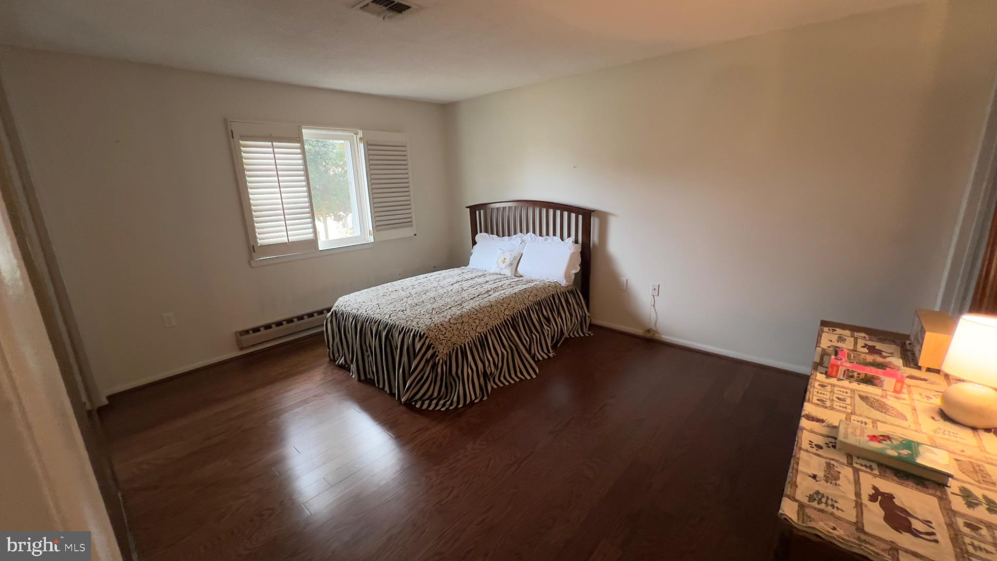 3525 Tarkington Lane, Unit 63B Silver Spring, MD 20906 - Photo 13 of 36 a bedroom with a bed and wooden floor