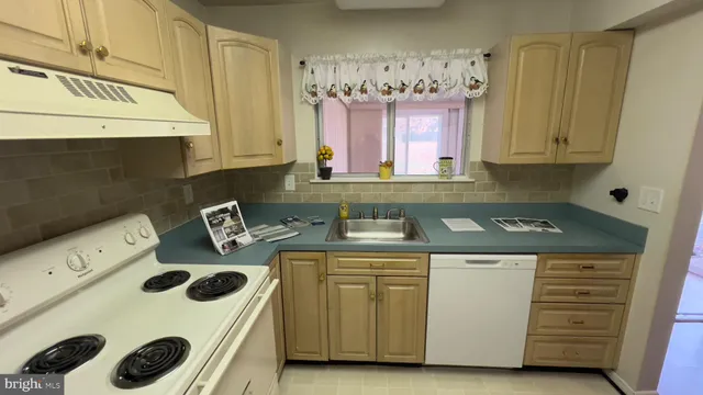a kitchen with appliances a refrigerator and cabinets