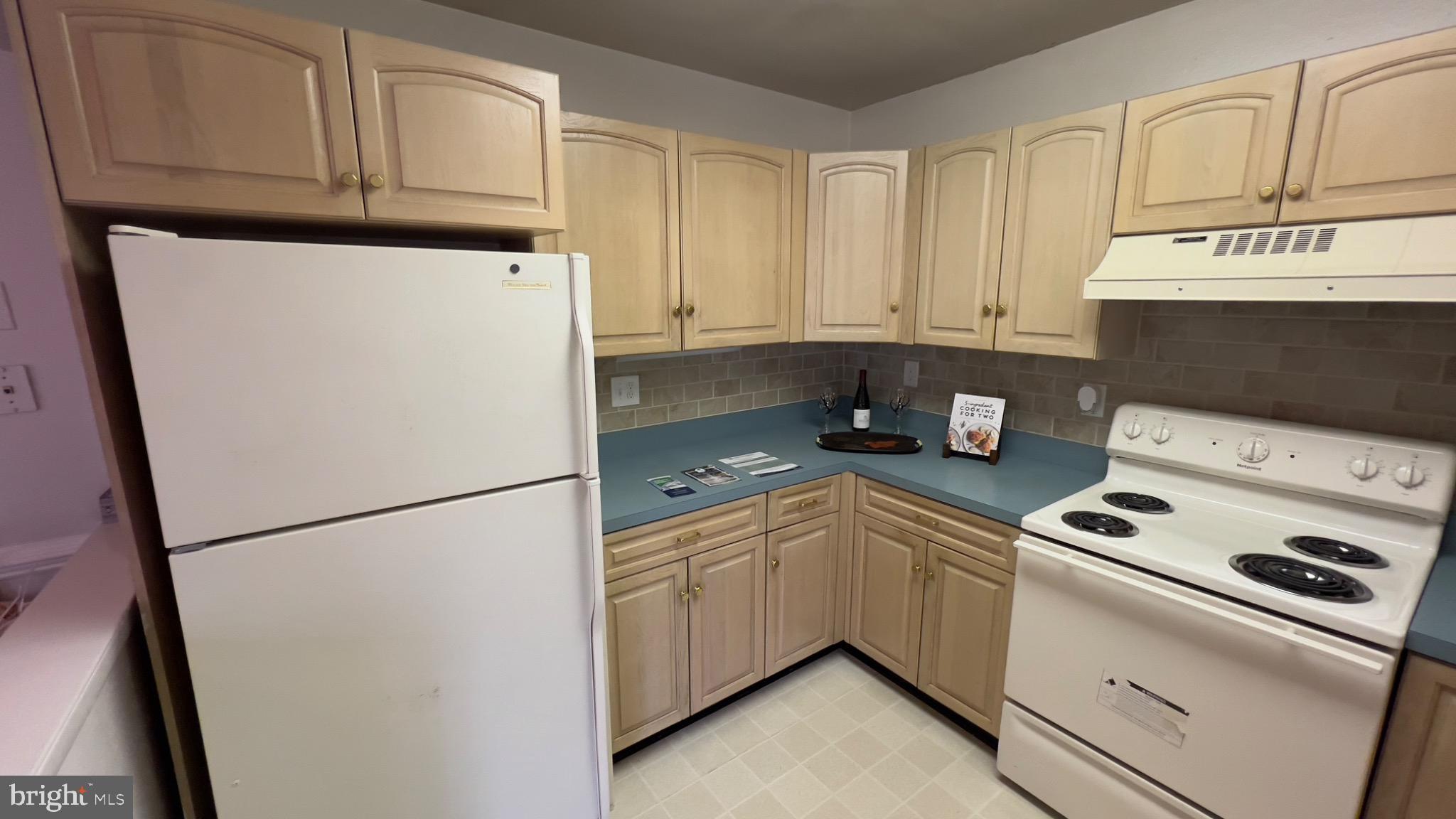 3525 Tarkington Lane, Unit 63B Silver Spring, MD 20906 - Photo 19 of 36 a kitchen with appliances a refrigerator and cabinets