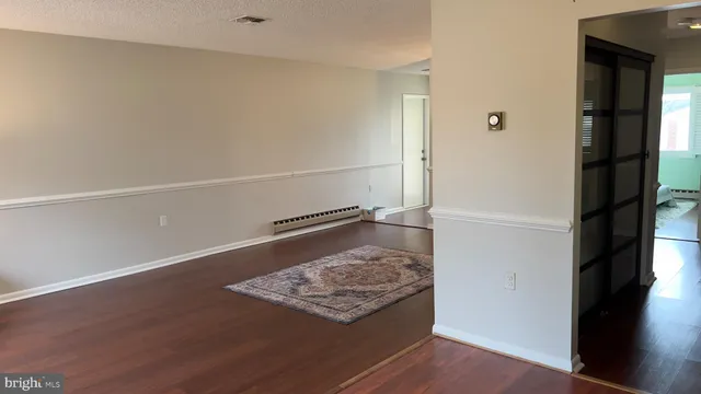 a view of a hallway to a livingroom with furniture