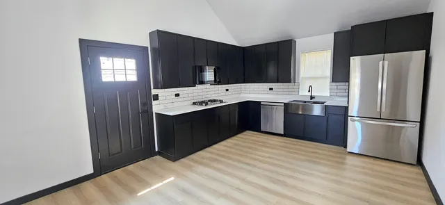 a kitchen with stainless steel appliances a refrigerator sink and cabinets