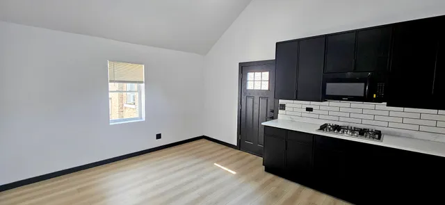 a kitchen with stainless steel appliances a sink dishwasher a stove and black cabinets