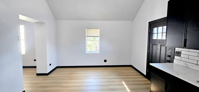 a view of a room with wooden floor and window