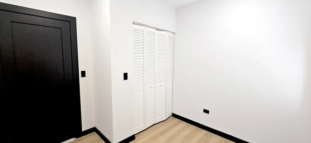 a view of a room with wooden floor and a window