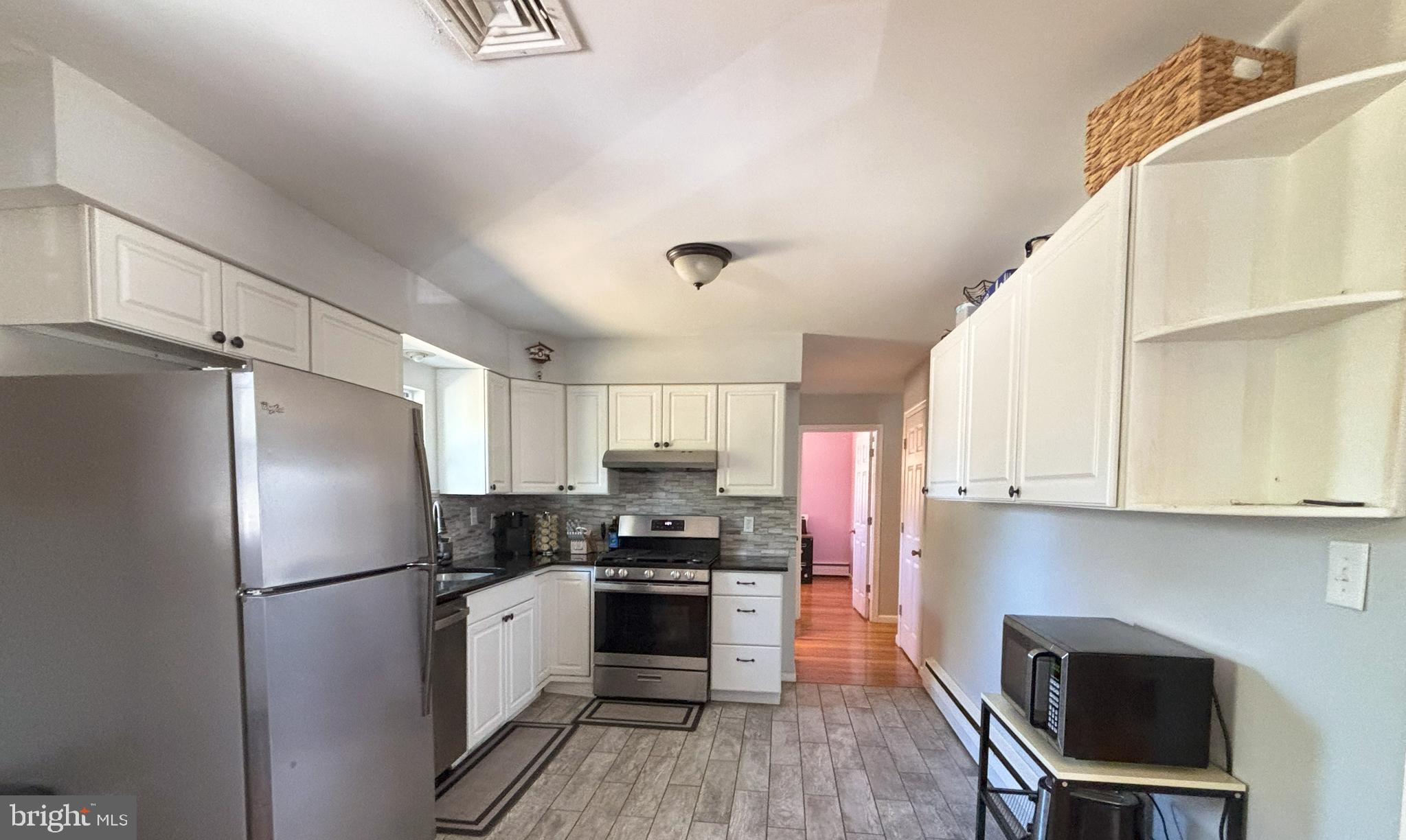 205 Lucas Avenue West Berlin, NJ 08091 - Photo 11 of 25 a kitchen with stainless steel appliances a refrigerator a stove a sink dishwasher and white cabinets with wooden floor