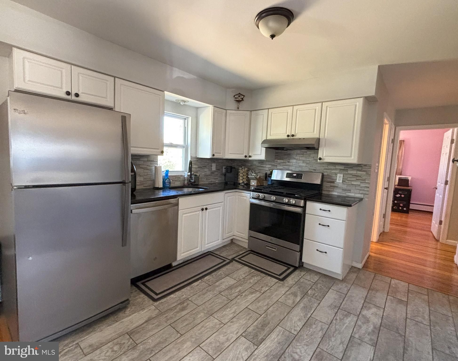 205 Lucas Avenue West Berlin, NJ 08091 - Photo 12 of 25 a kitchen with granite countertop a refrigerator a sink and white cabinets