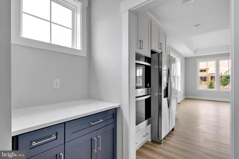 a kitchen with stainless steel appliances a refrigerator and a hard wood floor