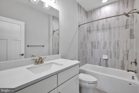 a bathroom with a sink a toilet and a large mirror