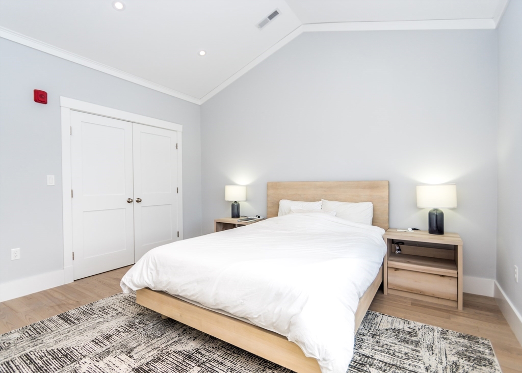 29 Cherry Street, Unit 2 Waltham, MA 02453 - Photo 12 of 32 a bedroom with a bed and a lamp