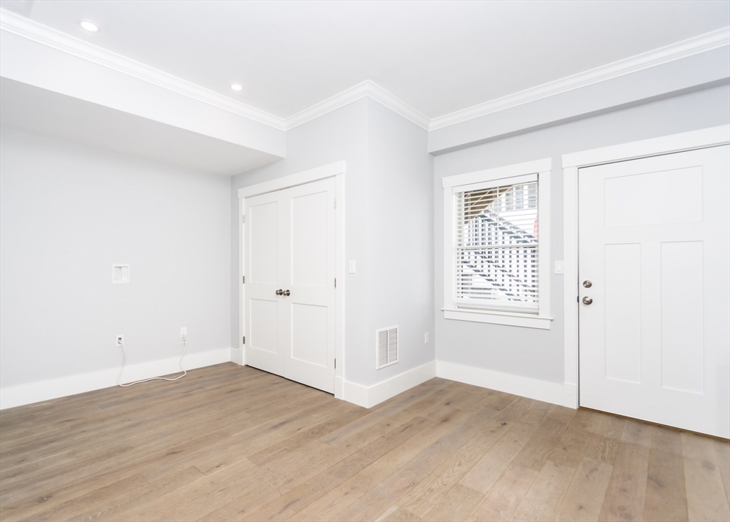 29 Cherry Street, Unit 2 Waltham, MA 02453 - Photo 14 of 32 an empty room with wooden floor and windows