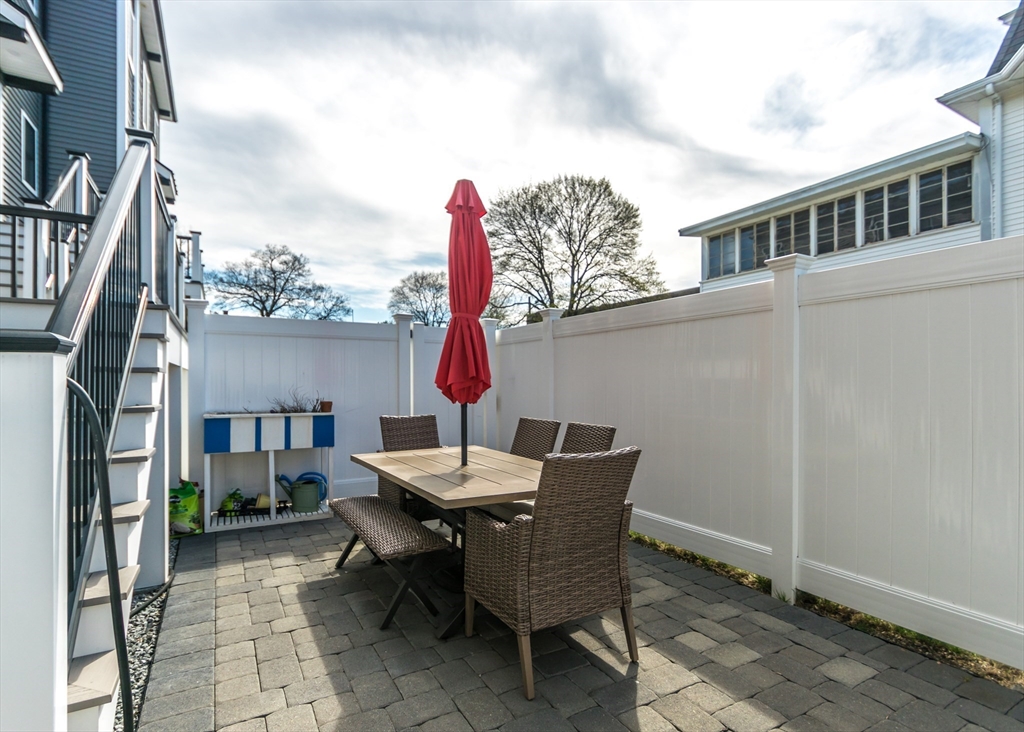 29 Cherry Street, Unit 2 Waltham, MA 02453 - Photo 26 of 32 a backyard of a house with barbeque oven table and chairs