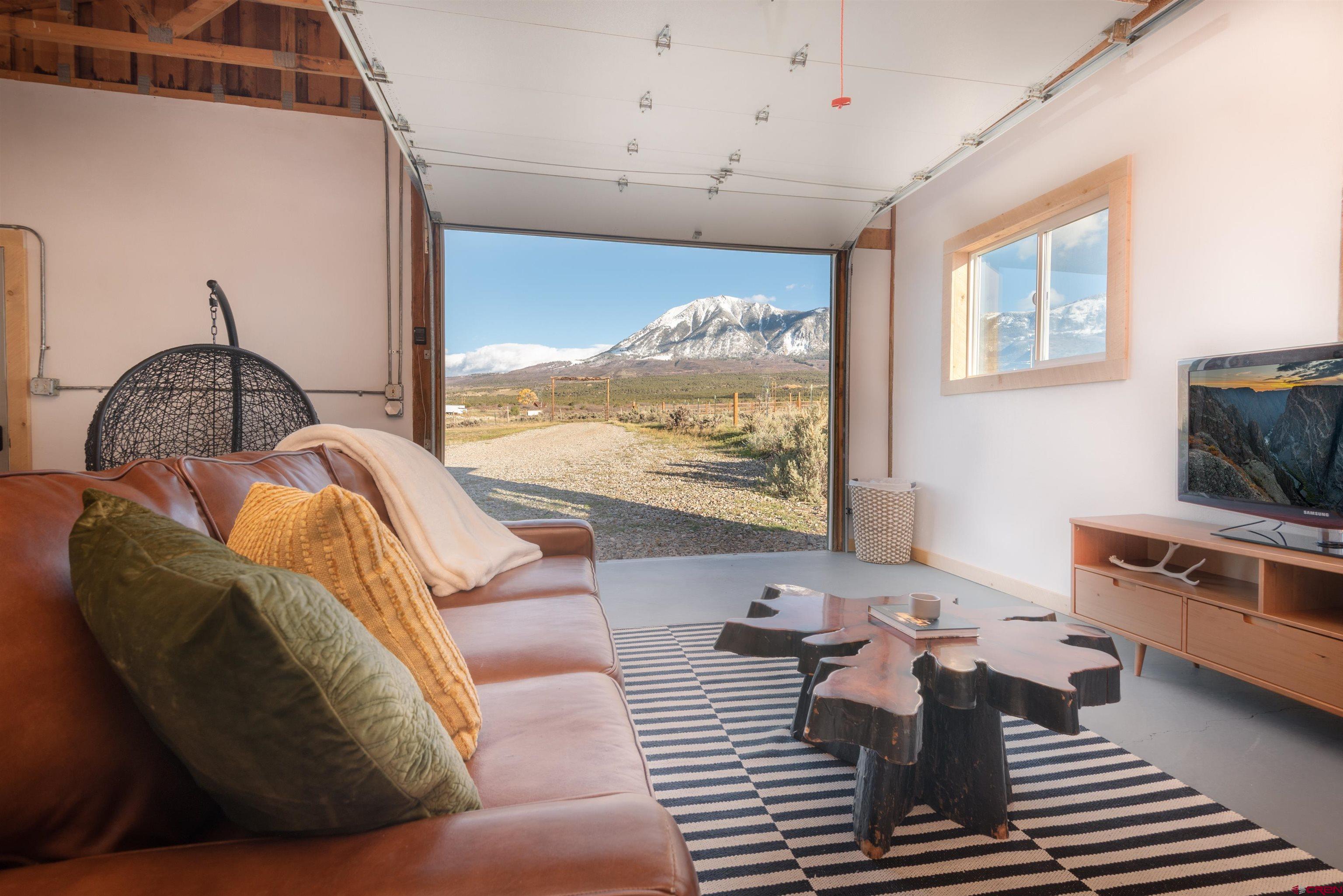 11531 4050th Road Paonia, CO 81428 - Photo 13 of 37 a living room with furniture a flat screen tv and a floor to ceiling window
