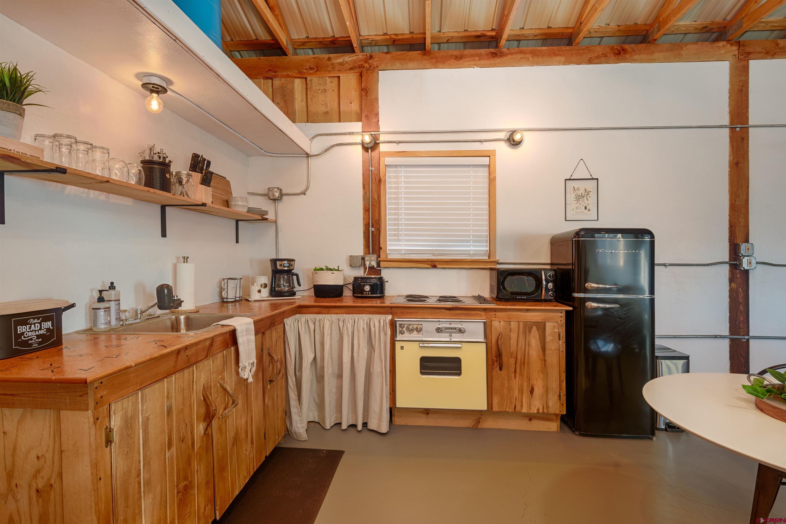 11531 4050th Road Paonia, CO 81428 - Photo 15 of 37 a kitchen with stainless steel appliances granite countertop a stove a sink dishwasher and a refrigerator with wooden floor