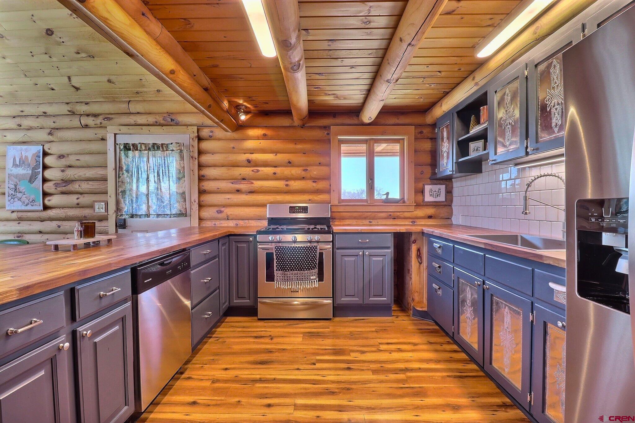 11531 4050th Road Paonia, CO 81428 - Photo 4 of 37 a large kitchen with stainless steel appliances granite countertop wooden cabinets and a stove top oven