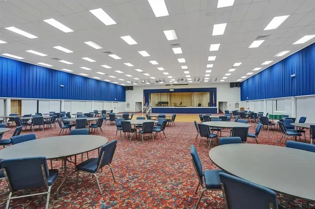 a kitchen with a dining table wooden floor and a view of living room