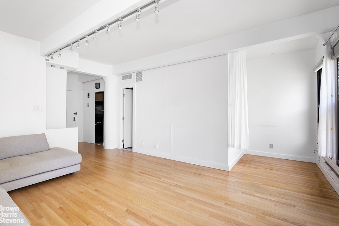 10 Christopher Street, Unit 5C Manhattan, NY 10014 - Photo 2 of 8 a view of an empty room with wooden floor and a window