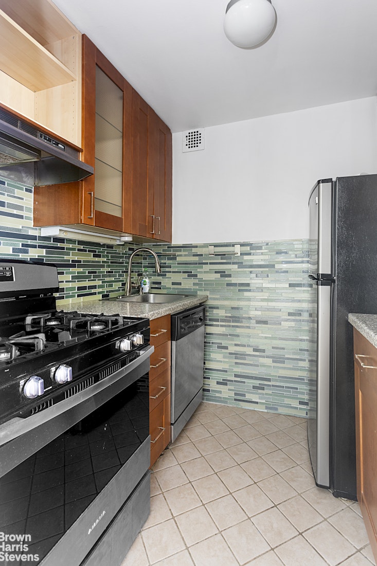 10 Christopher Street, Unit 5C Manhattan, NY 10014 - Photo 4 of 8 a kitchen with stainless steel appliances granite countertop a stove and a refrigerator