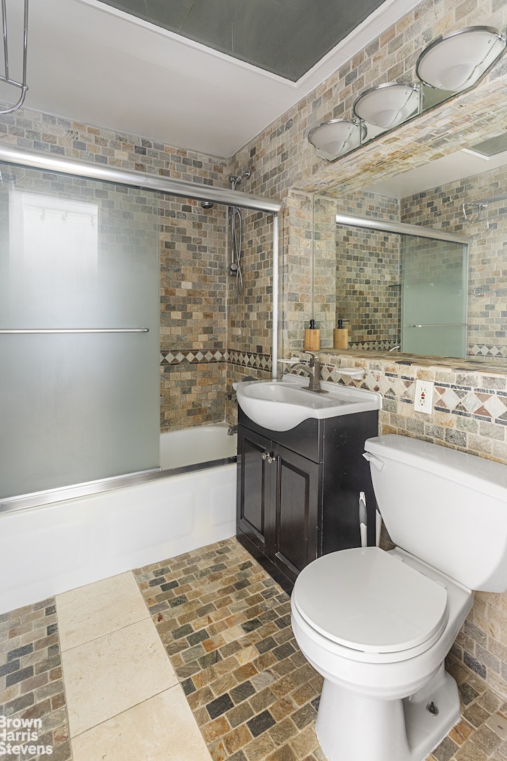 10 Christopher Street, Unit 5C Manhattan, NY 10014 - Photo 5 of 8 a bathroom with a sink toilet and shower