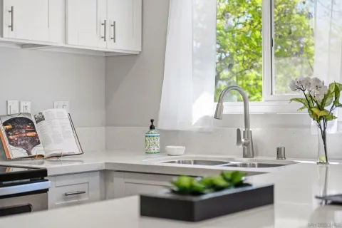 a kitchen with a stove a sink and a white cabinets