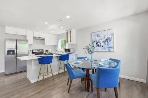 a view of a dining room with furniture wooden floor and a kitchen