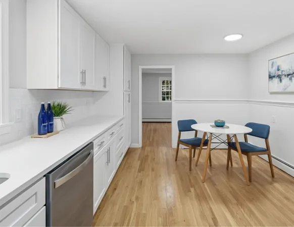 a kitchen with stainless steel appliances dining table chairs and wooden floor