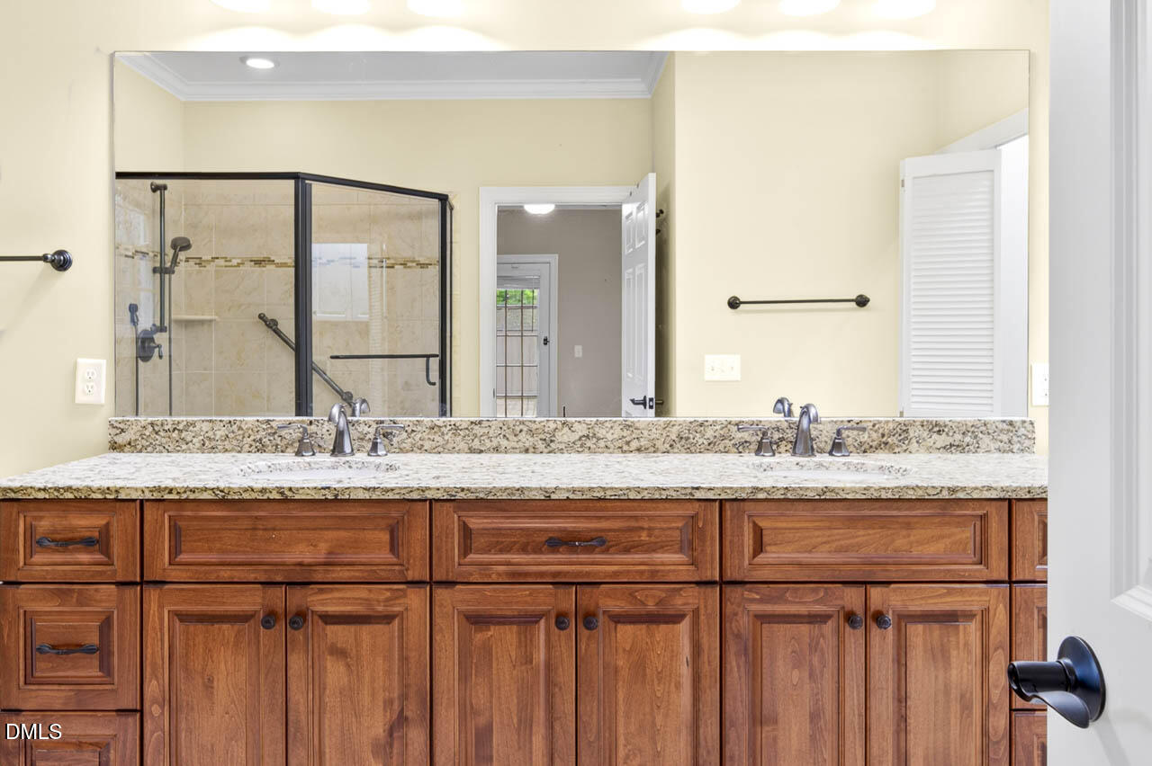 2209 Lodestar Drive Raleigh, NC 27615 - Photo 15 of 50 a bathroom with a granite countertop sink and a mirror