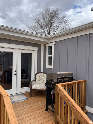 558 North N Cres Road Roosevelt, UT 84066 - Photo 5 of 31 Wood-finish deck featuring double French doors with black hardware, gray board-and-batten siding, and white trim