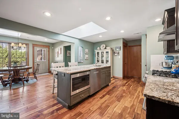 a kitchen with stainless steel appliances granite countertop a stove and a wooden floors
