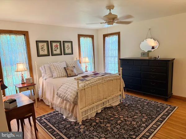 a bedroom with a bed and dresser with mirror